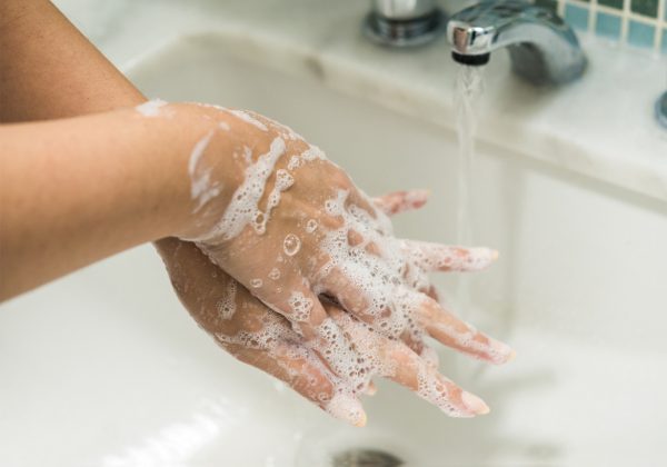 Foto em detalhe de mãos sobrepostas. Elas estão cheias de espuma
