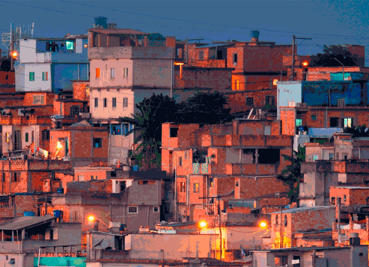 Foto de uma favela vista de longe com diversas casas ainda não terminadas